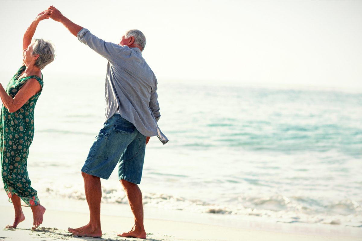 Retired couple dancing on a beach