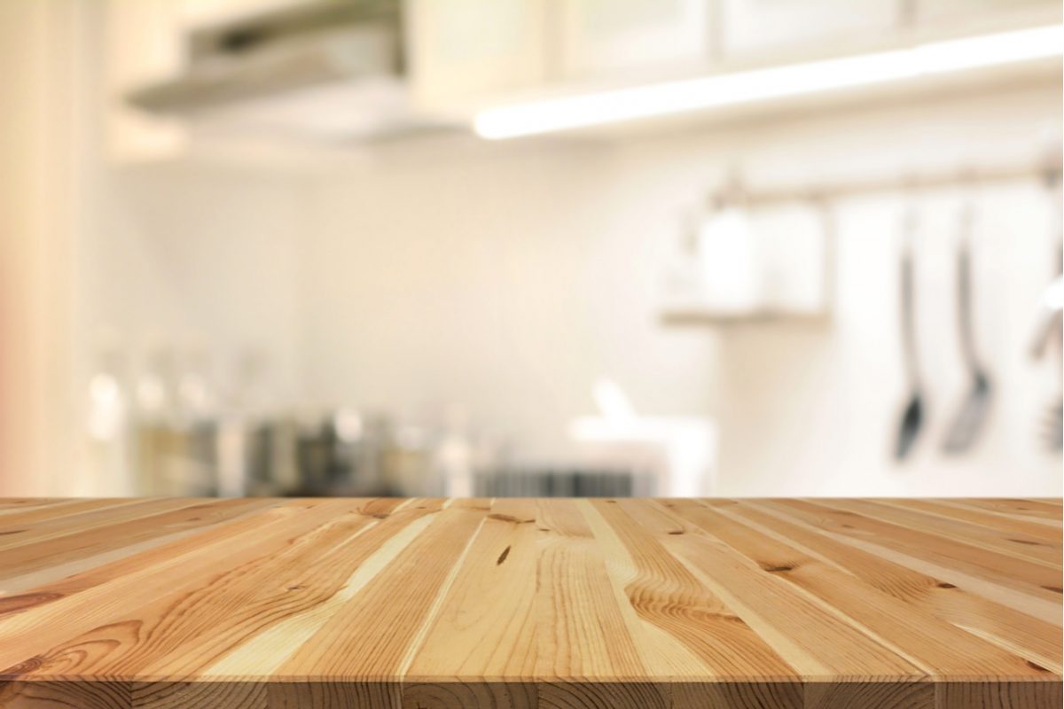 Wooden kitchen island with blurred kitchen in the background