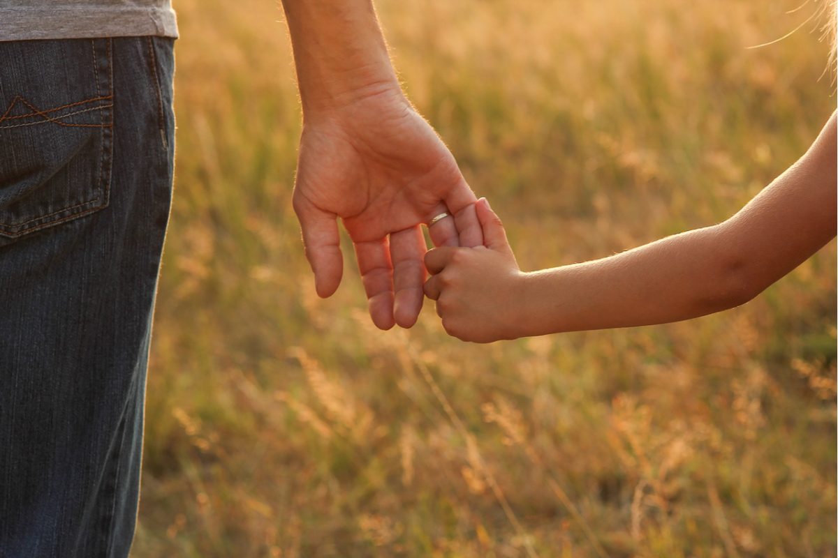 Close-up of a parent holding a child’s hand