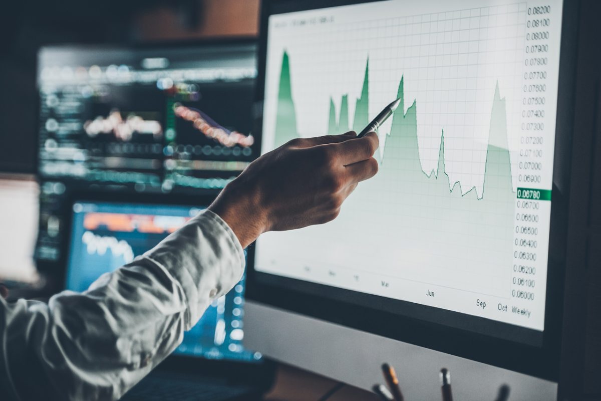 A man pointing to a screen showing data on a chart