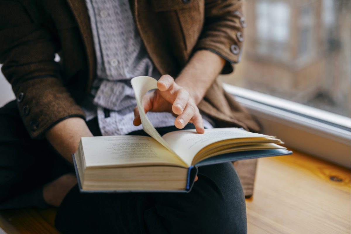 A close up of a man reading a book