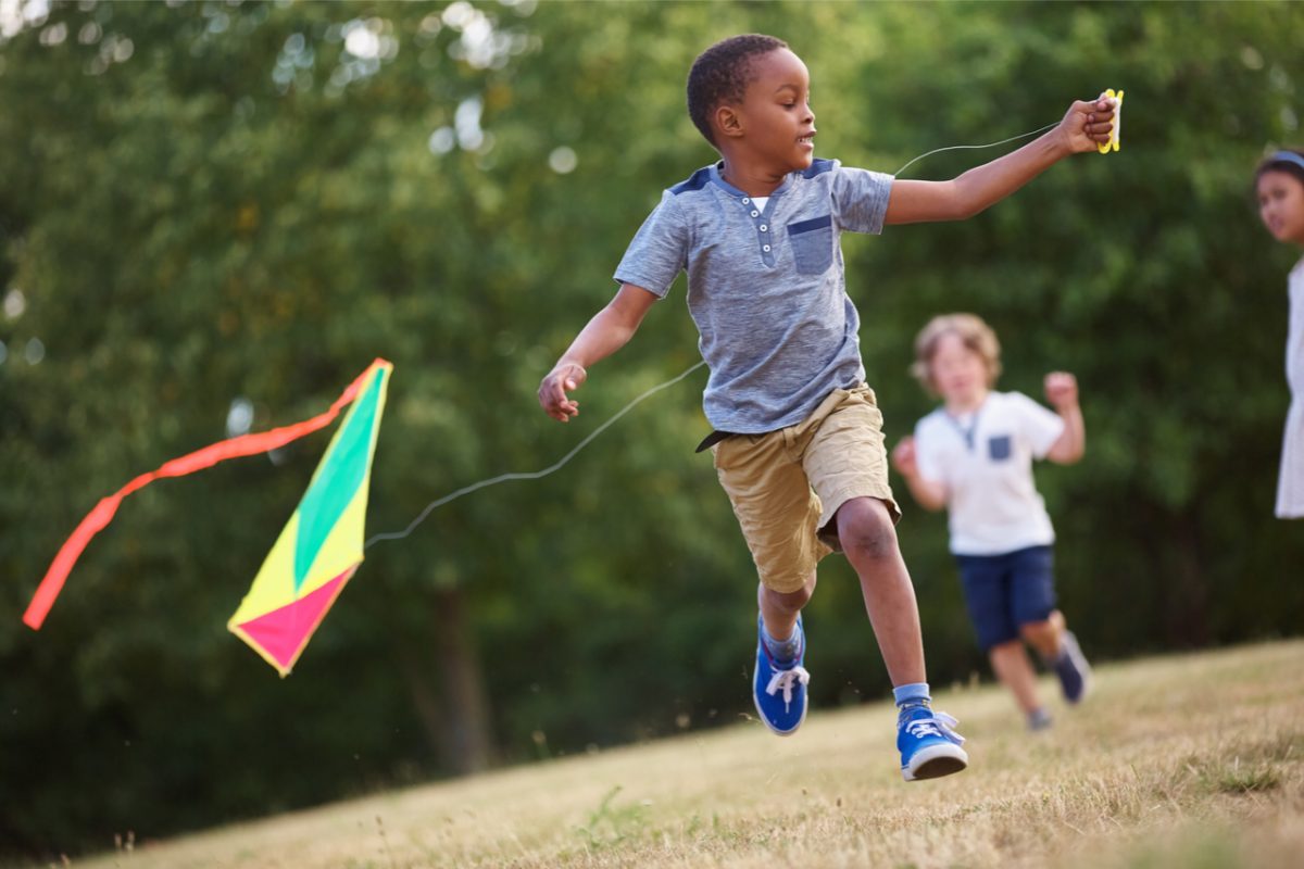 A child running and playing with a kite.