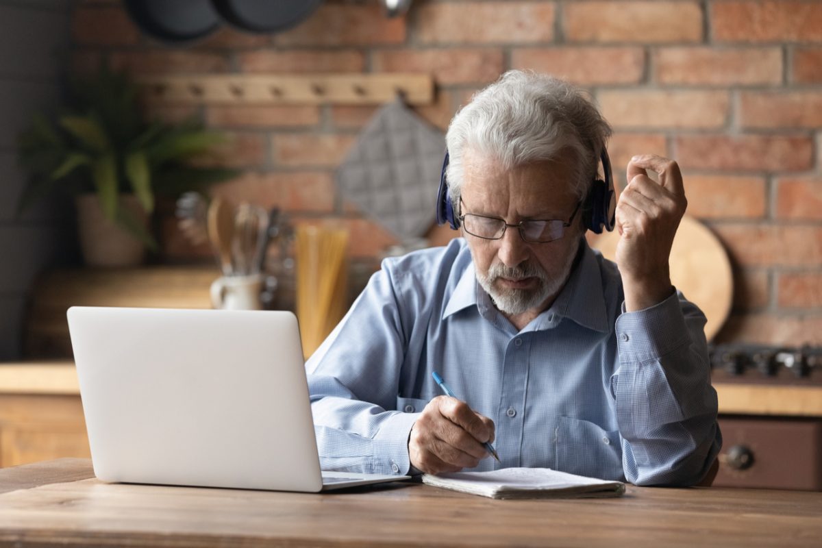 An older man working on a laptop.