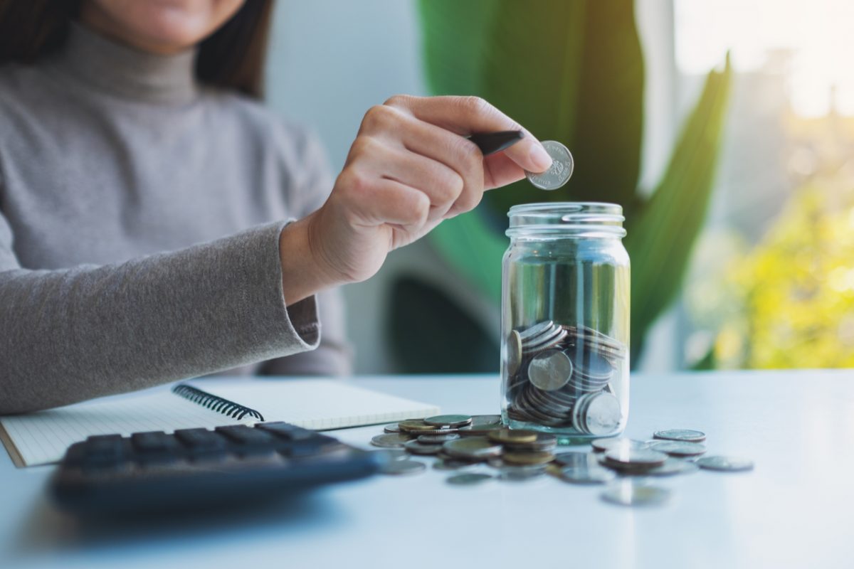 A child putting money in a jar.