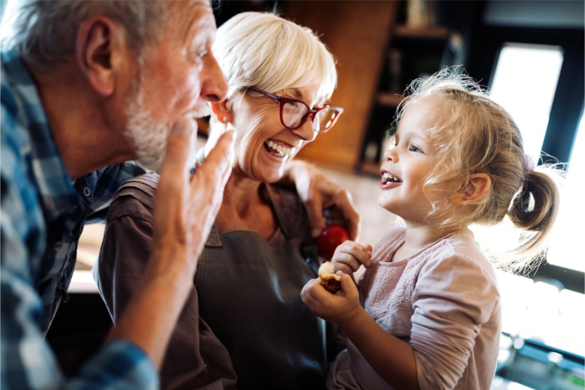 Grandparents playing with their granddaughter.