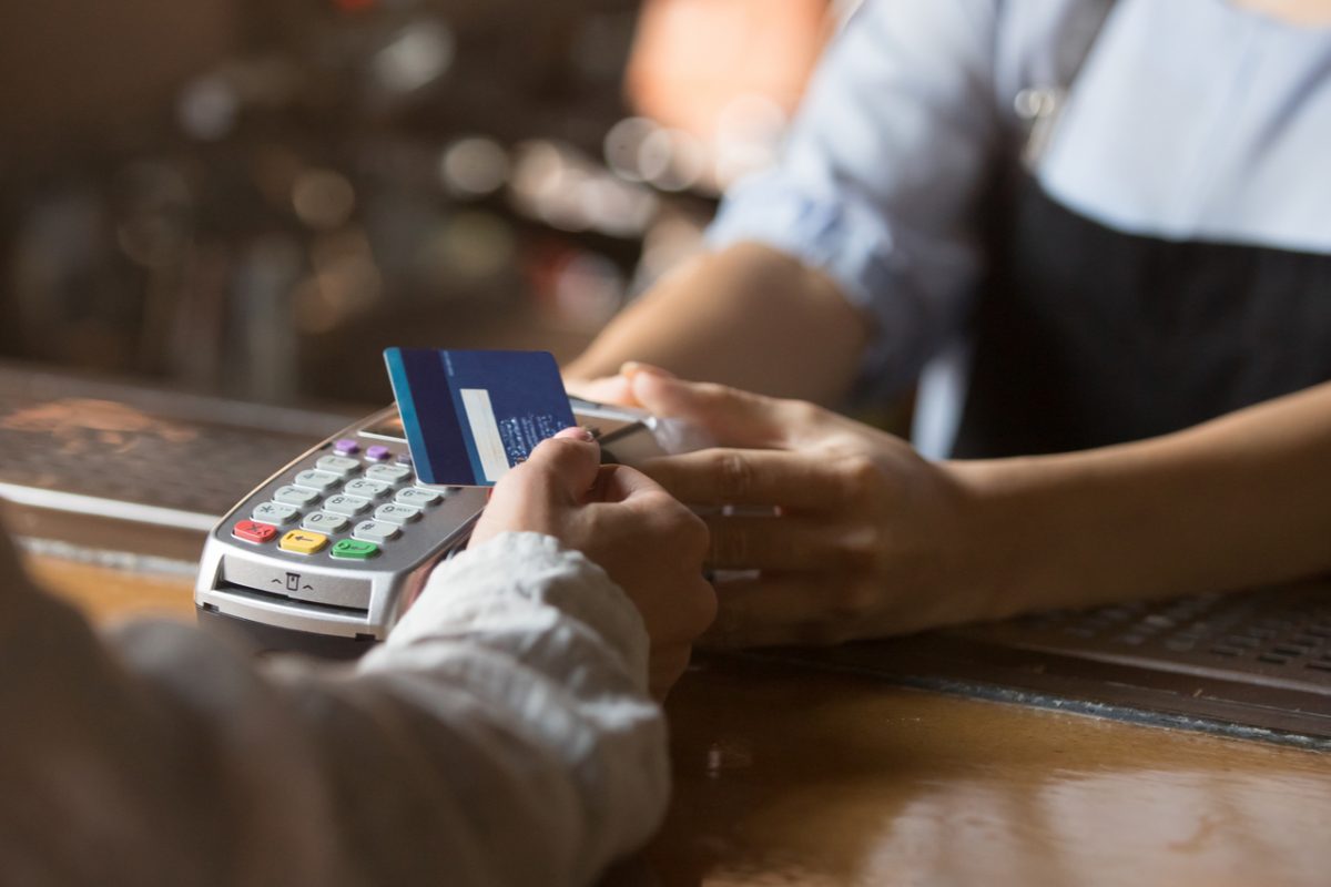 Someone paying in a café using a contactless card.