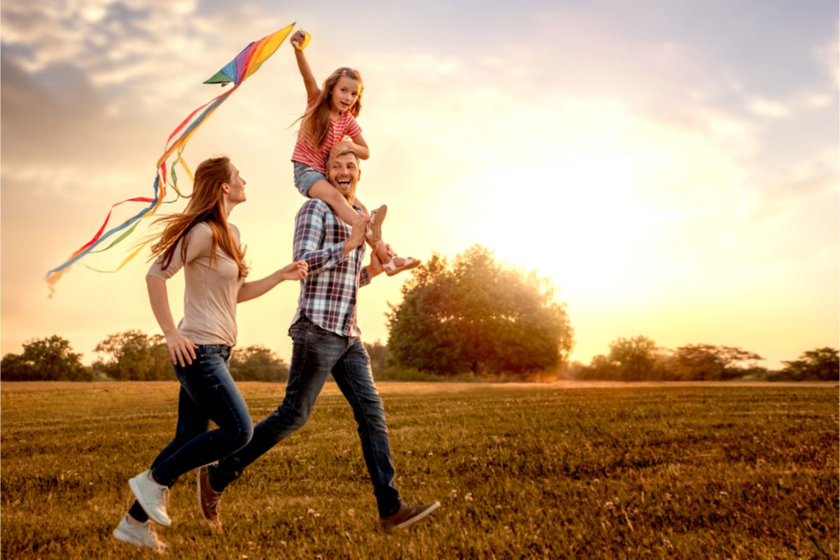 A family in a field with a kite.