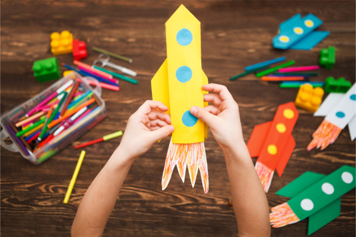 A child making a rocket out of paper.