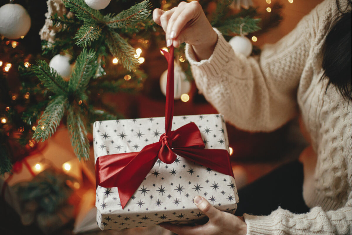 A woman unwrapping a Christmas gift.