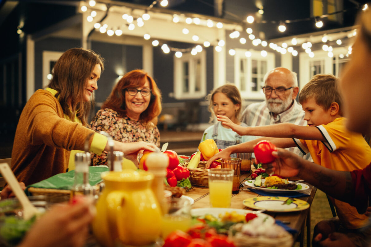 A happy family eating dinner outside.