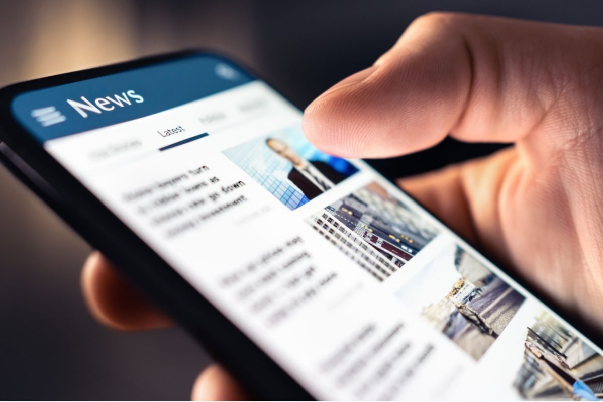 A person looking at a news feed on their phone.